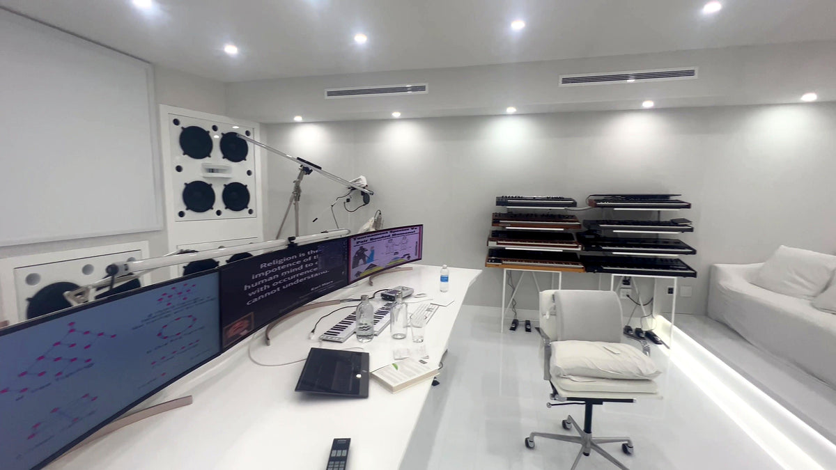 Finished all-white control room in the Calabasas studio, with speakers set into the soffit walls and a custom white desk