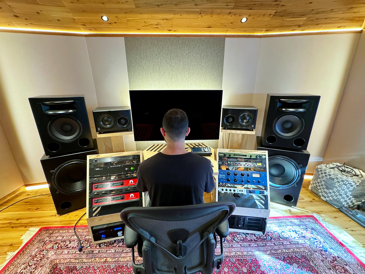 Control room with a fabric-wrapped front wall, a cedar ceiling with LED cove lighting and a large rug