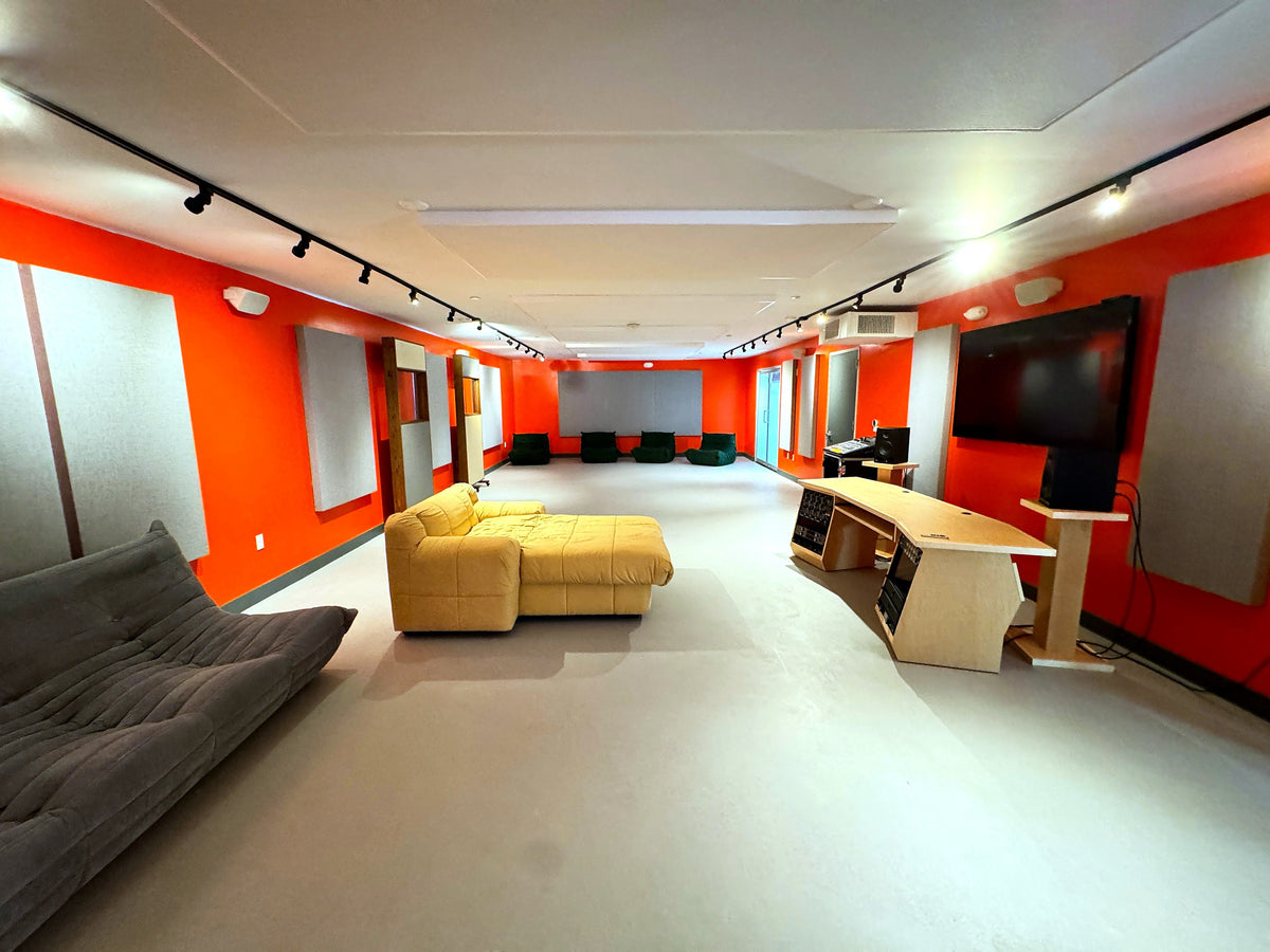 Long tracking room with orange walls, ceiling clouds and wall panels