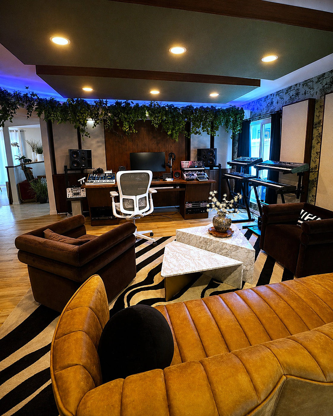 Writing room and lounge with a dropped soffit, blue LED cove lighting, trailing plants and fabric wall panels
