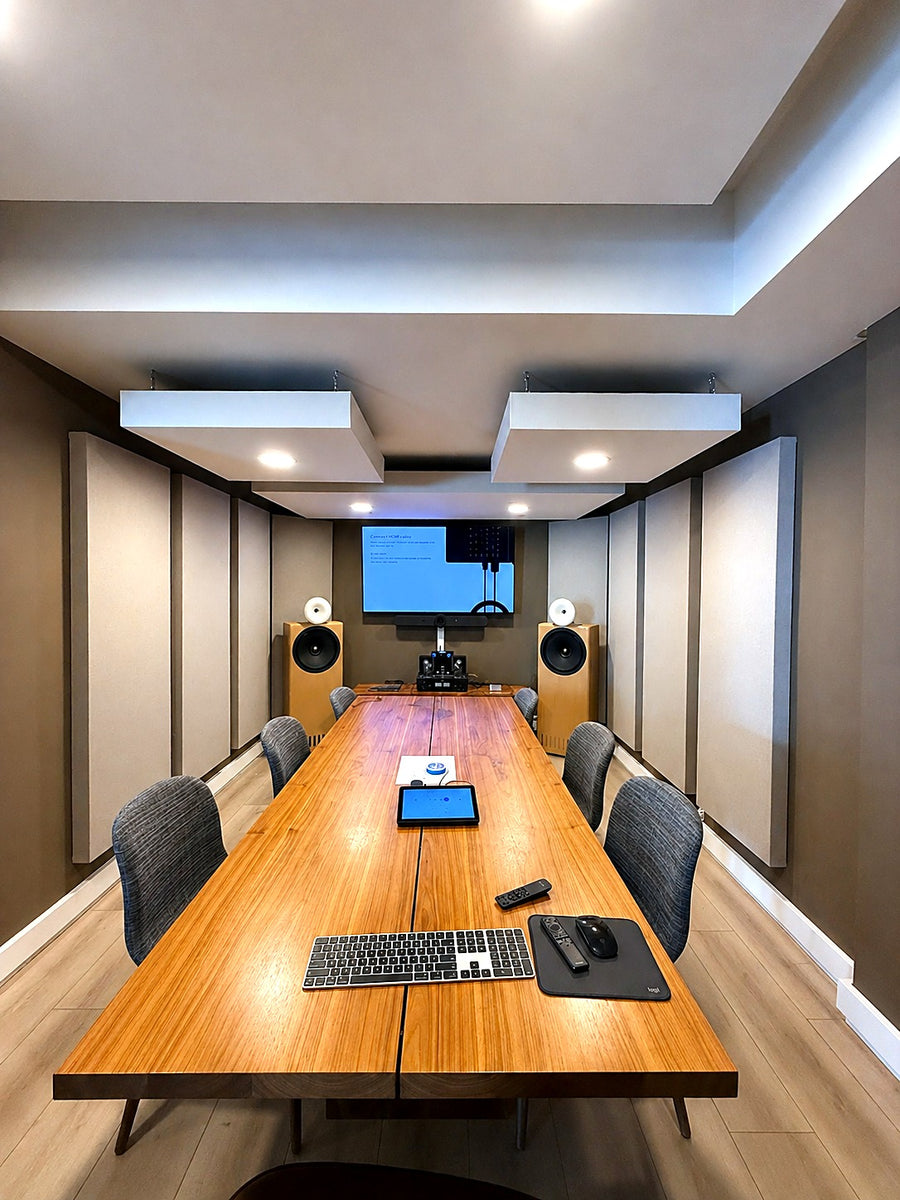 Conference room with two suspended acoustic ceiling clouds, recessed lighting and full height fabric acoustic panels along both walls