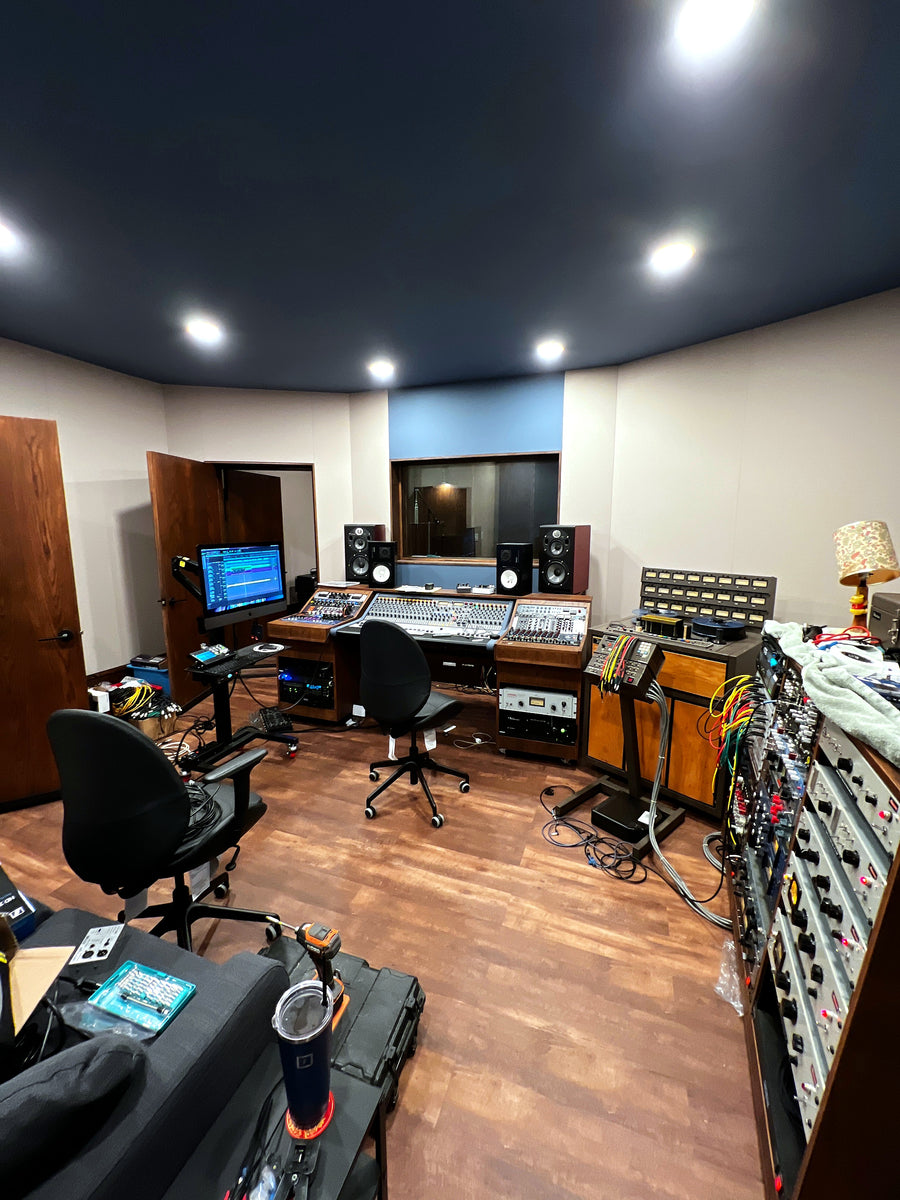 Control room with a large-format mixing console, patch bays and outboard racks