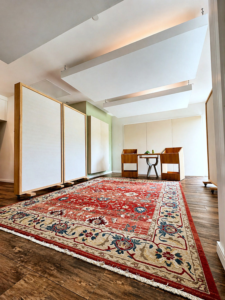 Bright live room with suspended acoustic ceiling clouds and wood-framed free-standing gobos on casters over a patterned rug