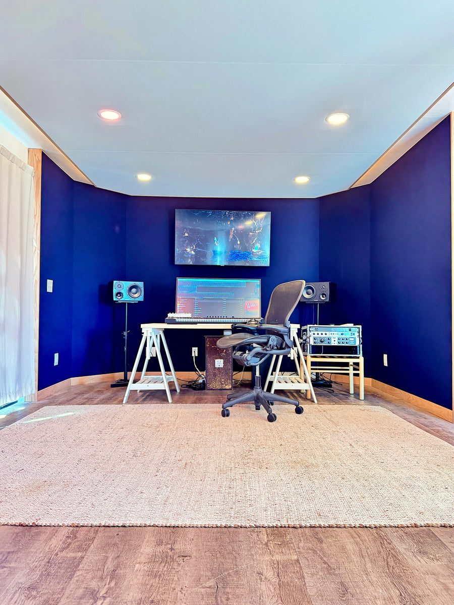 Mix room with navy walls, a floating ceiling soffit with recessed lights and a trestle desk over a large rug