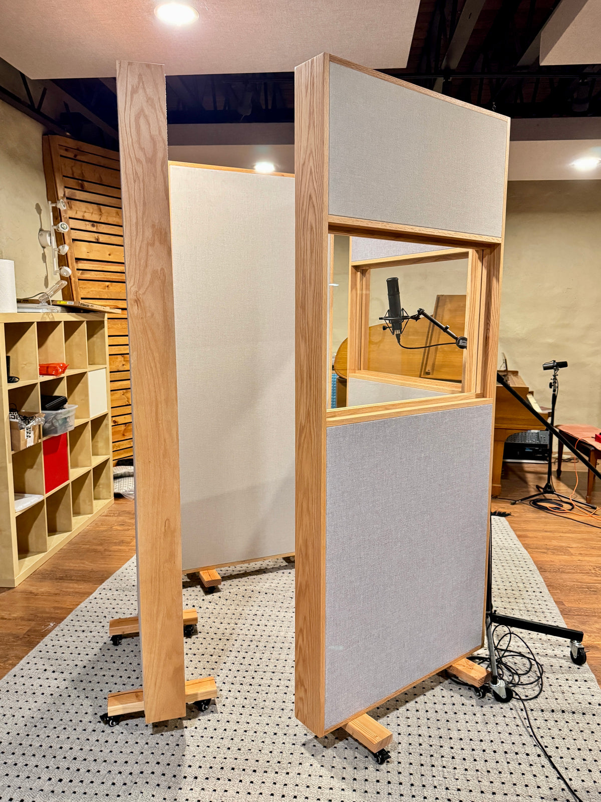 Red oak free-standing gobos on casters, with fabric panels and acrylic viewing windows, set up around a microphone