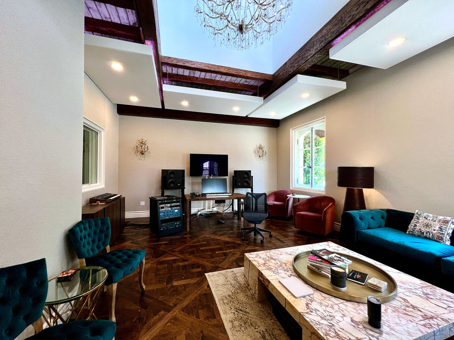 Open-plan studio lounge with a coffered wood ceiling, seating area and production desk